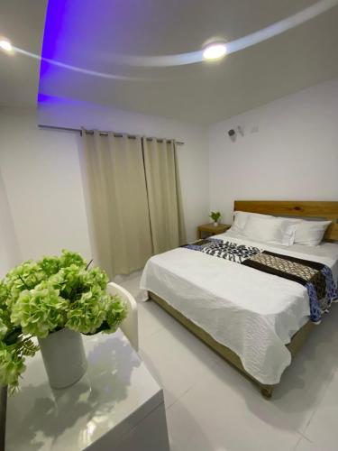a bedroom with a bed and a table with a plant at Verde Bonavita Luxury II in Santiago de los Caballeros
