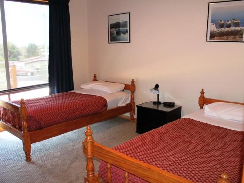 1 dormitorio con 2 camas y ventana en Hazards House en Coles Bay