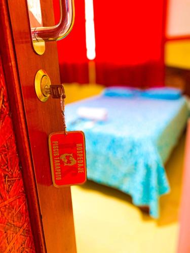 a door with a red tag in a room with a bed at HOSPEDAJE PISCIS TARAPOTO in Tarapoto