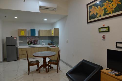 a kitchen with a table and chairs and a refrigerator at My Daily Homestay - Miri Times Square in Miri