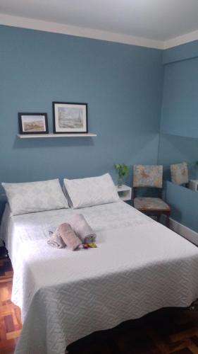 Apartamento/Studio centro florianopolis في فلوريانوبوليس: غرفة نوم بسرير ابيض كبير بجدران زرقاء