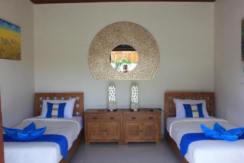 a bedroom with two beds and a mirror at Villa Indah 2 in Sanur