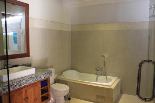 a bathroom with a tub and a toilet and a sink at Villa Indah 2 in Sanur