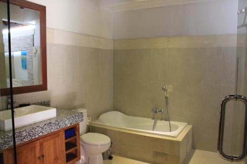 Un baño con bañera, inodoro y lavabo. en Villa Indah 2, en Sanur