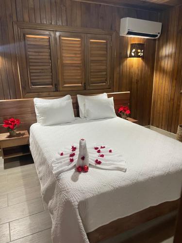 a bedroom with a white bed with roses on it at Hacienda La Huerta Puerto Plata, 1 BDR in San Felipe de Puerto Plata