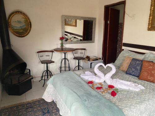 een slaapkamer met een bed met hartdecoratie bij Hospedagem Recanto das Orquideas in Quatis