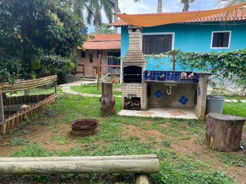 a house with a brick oven in a yard at Hospedagem Recanto das Orquideas in Quatis
