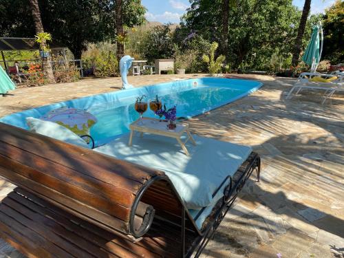 a bench sitting next to a swimming pool at Hospedagem Recanto das Orquideas in Quatis