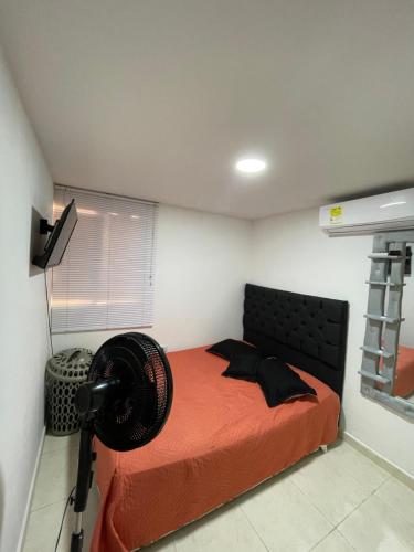 a bedroom with a bed with a fan on it at Habitación doble in Barranquilla