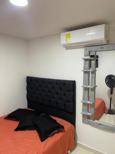 - une chambre avec un lit doté d'une tête de lit noire dans l'établissement Habitación doble, à Barranquilla