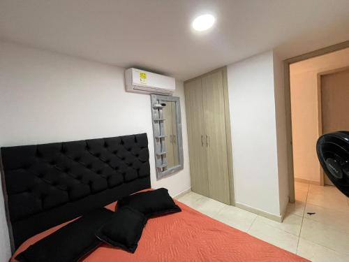 - une chambre avec un lit noir et une couverture rouge dans l'établissement Habitación doble, à Barranquilla