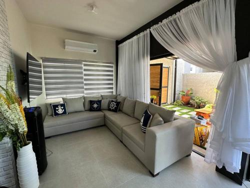 een woonkamer met een bank en een groot raam bij Seafront OnCall - private jacuzzi with 4 cozy bedrooms in San Juan