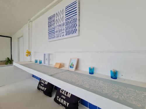 a white room with a counter with blue vases on it at The Hut Koh Mak Sea View in Ko Mak