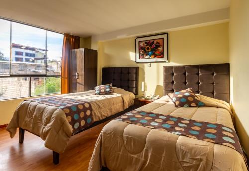 a hotel room with two beds and a window at Algo Mas Hotel - Santa Beatriz in Cusco