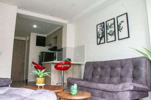 Apartamento encantador en bello(cabañas) في بيلو: غرفة معيشة مع أريكة وطاولة