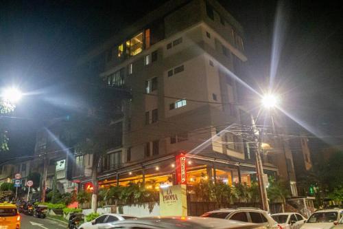 een gebouw in een stadsstraat 's nachts met auto's bij Apartamento encantador en bello(cabañas) in Bello