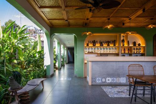 un restaurante con paredes verdes y un bar en Hami Garden - Authentic & Natural Resort, en Buôn Ju