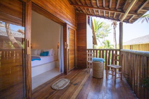 a porch of a resort with a bed and a bedroom at Café Jeri Hotel - Adults Only in Jericoacoara