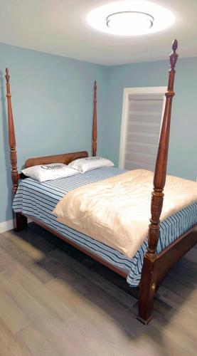 a bed in a bedroom with a blue wall at Queen bedroom in Windsor