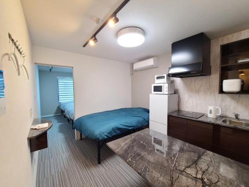 a small room with a bed and a kitchen at パーリーフラッツ品川高輪台 PEARLY FLATS Shinagawa Takanawadai in Tokyo