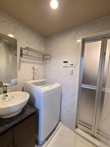 a bathroom with a sink and a toilet and a shower at パーリーフラッツ品川高輪台 PEARLY FLATS Shinagawa Takanawadai in Tokyo