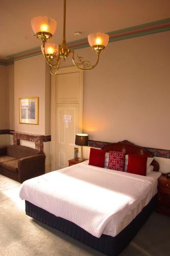 a bedroom with a large bed with red pillows at The Hotel Shamrock in Bendigo