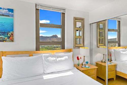 a bedroom with two beds and two windows at Aloha Hawaii, Waikiki Condo with Great Mountain Views & Free Parking! in Honolulu