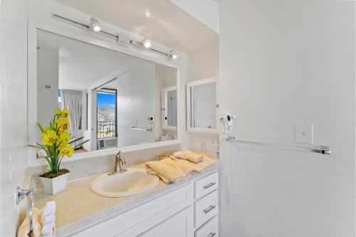 a bathroom with a sink and a large mirror at Aloha Hawaii, Waikiki Condo with Great Mountain Views & Free Parking! in Honolulu