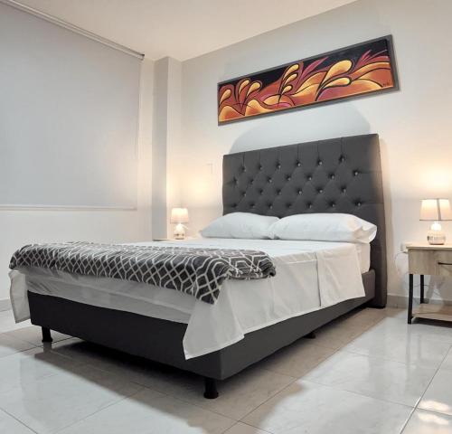 1 dormitorio con 1 cama grande y cabecero negro en Acogedor Apartaestudio, en Pitalito