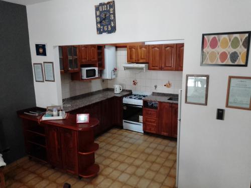 聖羅莎的住宿－Complejo Semaso，厨房配有木制橱柜和炉灶烤箱。