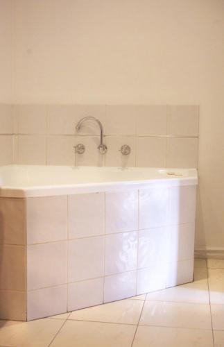 a bath tub with a faucet in a bathroom at The Hotel Shamrock in Bendigo