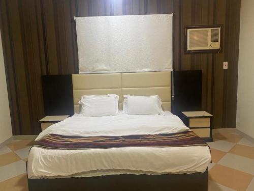 a bed with two pillows on it in a room at نزيل للشقق المفروشة in Taif
