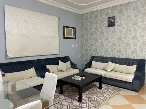 a living room with two couches and a table at نزيل للشقق المفروشة in Taif