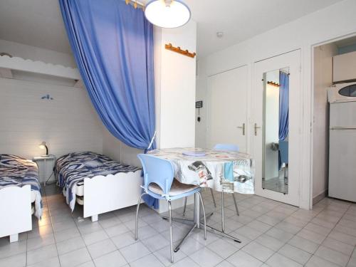 une chambre avec deux lits, une table et des chaises dans l'établissement Charmant T1 avec Loggia au Sud, Calme, Près Centre-Ville, Garage, Bien Équipé - FR-1-553-58, à Balaruc-les-Bains