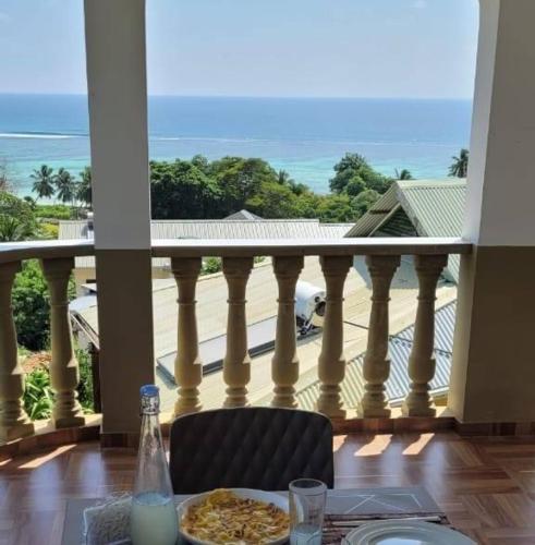 une table avec une assiette de nourriture sur un balcon dans l'établissement Sawa self catering, à Pointe Au Sel 