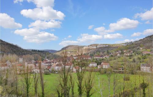 a town in a green field with mountains in the background at Amazing Home In Marcilhac Sur Célé in Marcilhac-sur-Célé