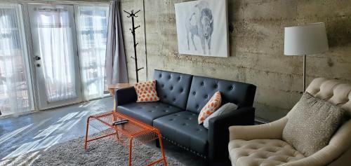 ein Wohnzimmer mit einem blauen Sofa und einem Stuhl in der Unterkunft Modern lofty studio in Midtown / Charming Old SW in Reno