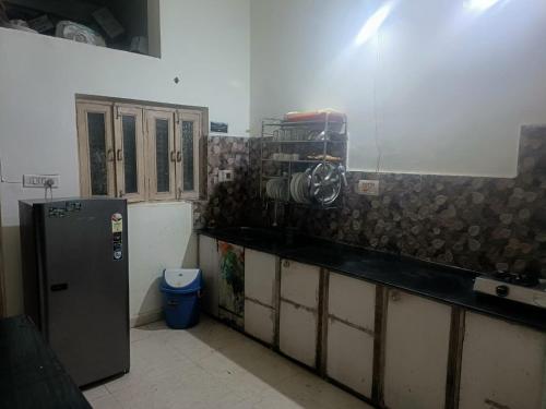 a kitchen with a counter and a refrigerator at Rani Homestay Khajuraho in Khajurāho