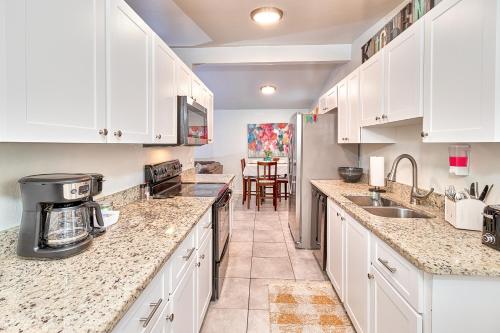 una cocina con encimeras de mármol y armarios blancos. en Convenient 4 Bedroom Home Centrally Located Tampa en Tampa