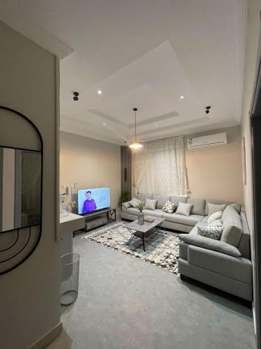uma sala de estar com um sofá e uma televisão de ecrã plano em دخول ذاتي - غرفة نوم وصالة جلوس (هادئة وخصوصية عالية) em As Sayl aş Şaghīr