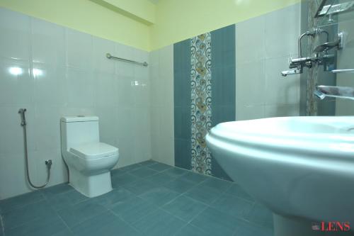 a bathroom with a toilet and a sink at Hotel Melungtse & Apartment in Tokna