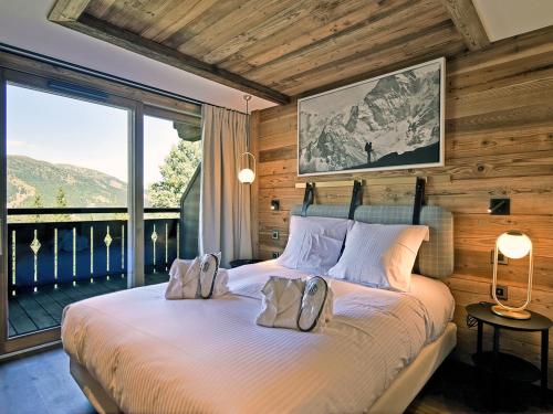sypialnia z dużym łóżkiem i dużym oknem w obiekcie Appartement lumineux avec balcon à 2 chambres doubles et services inclus, skis aux pieds - FR-1-613-65 w mieście Les Allues