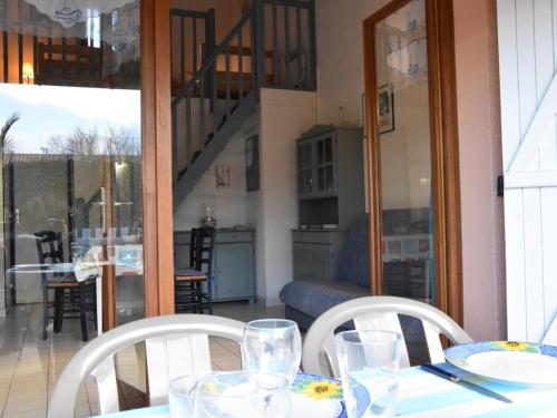 une table avec deux chaises blanches et une salle à manger dans l'établissement Maison 2 pièces mezzanine, 5 couchages, piscine, près de la plage - Gruissan - FR-1-229-828, à Gruissan