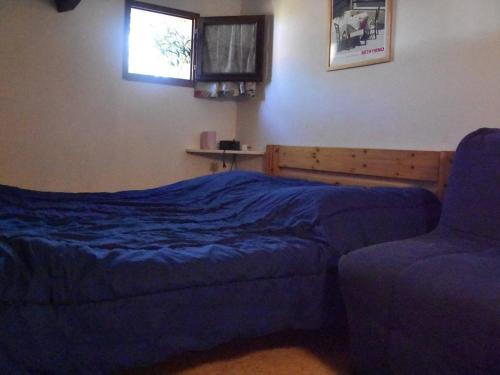 une chambre avec un lit, une chaise et une fenêtre dans l'établissement Maison en bord de mer avec terrasse ensoleillée, mezzanine, et parking privé - 4 couchages à Gruissan - FR-1-229-843, à Gruissan