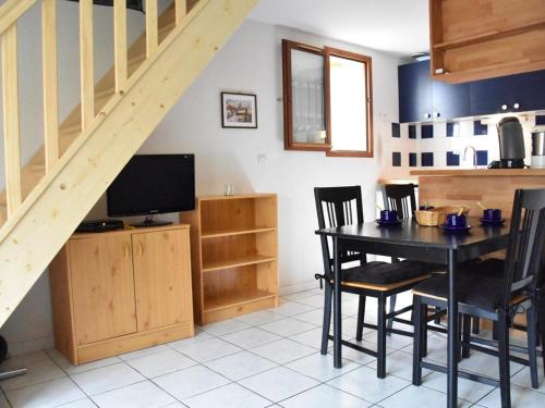 une salle à manger avec une table et des chaises et un escalier dans l'établissement Maison de vacances à Gruissan - 5 couchages, piscine, proche mer et commerces - FR-1-229-816, à Gruissan