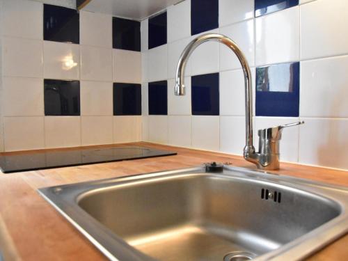 - un évier en acier inoxydable dans une cuisine revêtue de carrelage bleu et blanc dans l'établissement Maison de vacances à Gruissan - 5 couchages, piscine, proche mer et commerces - FR-1-229-816, à Gruissan