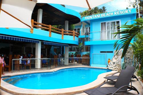 a swimming pool in front of a hotel at Montani Beach Resort Puerto Galera powered by Cocotel in Puerto Galera