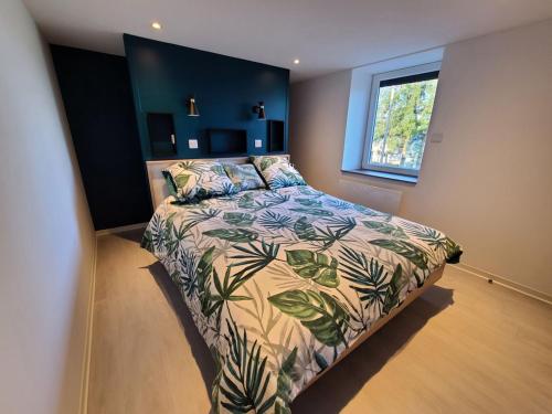 1 dormitorio con 1 cama con un edredón colorido en Gîte Plombières-les-Bains, 4 pièces, 5 personnes - FR-1-589-432, en Plombières-les-Bains