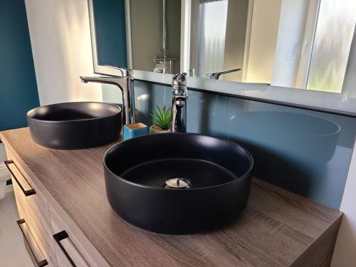 a bathroom with a black sink and a mirror at Gîte de charme avec sauna, spa et terrain de pétanque à Plombières-les-Bains, idéal en famille - FR-1-589-432 in Plombières-les-Bains