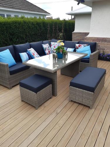 a patio with a table and chairs on a deck at Rosies Place in Oamaru